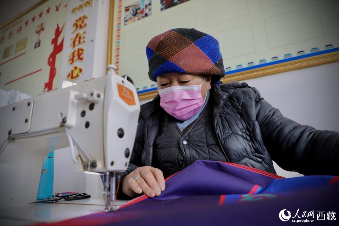 農(nóng)牧民專業(yè)合作社里的村民正在制作門簾。人民網(wǎng) 次仁羅布攝