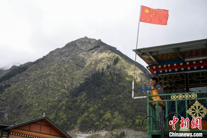 村民站在樓房上觀望?！钊A峰 攝