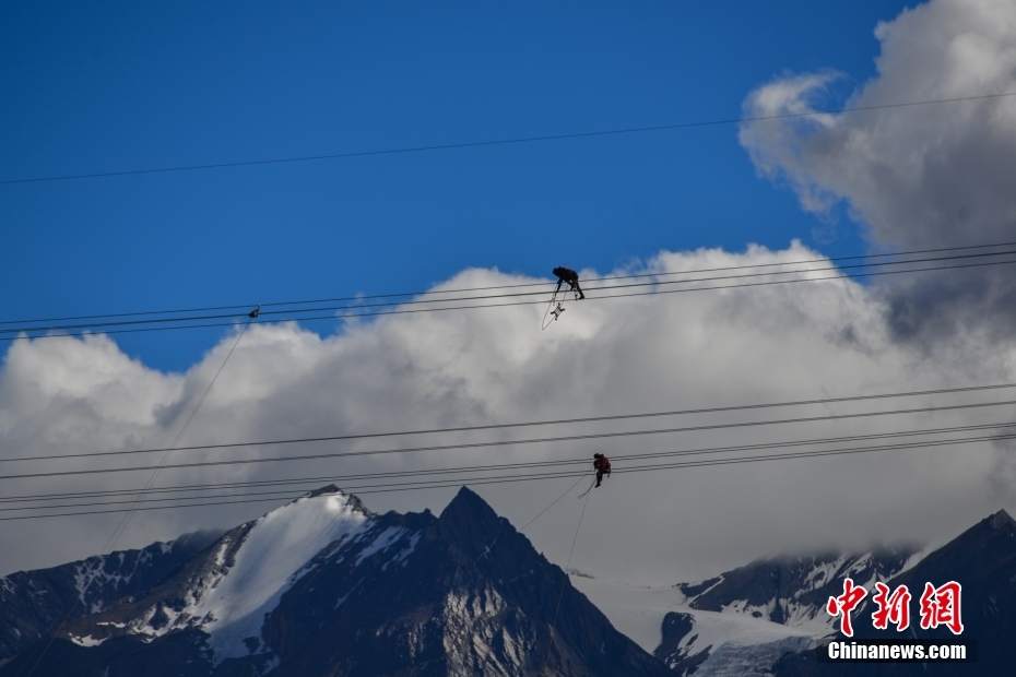 資料圖為2020年6月23日，西藏阿里聯(lián)網(wǎng)工程施工人員在日喀則希夏邦馬雪山附近進行走線作業(yè)，安裝絕緣設備。 <a target='_blank' href='/'><p  align=