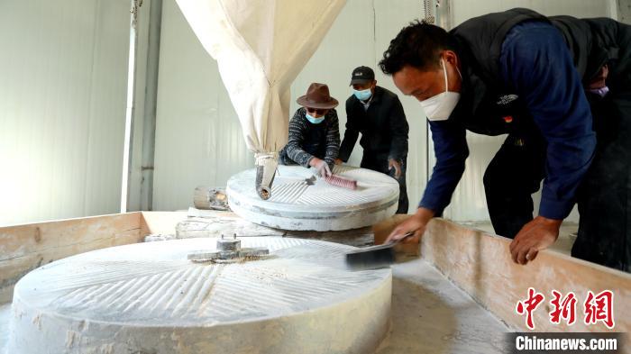 圖為合作社負(fù)責(zé)人完成糌粑加工后清掃水磨設(shè)施?！〖卫杩h融媒體中心供圖