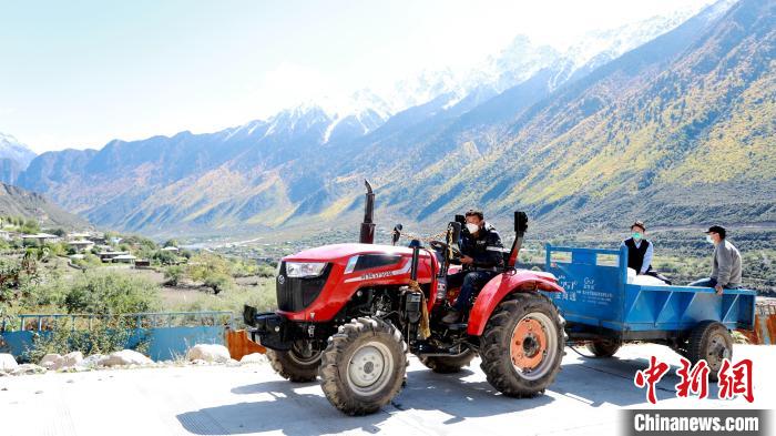 圖為工作人員將把加工完成的糌粑運(yùn)送至村民手中。　嘉黎縣融媒體中心供圖