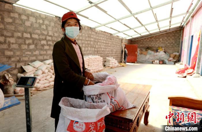 圖為寧重崗村村民扎西才措把自家的油菜籽送到合作社銷售?！〖卫杩h融媒體中心供圖