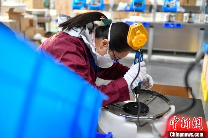 圖為工人正在組裝炊具?！∝暩聛硭?攝