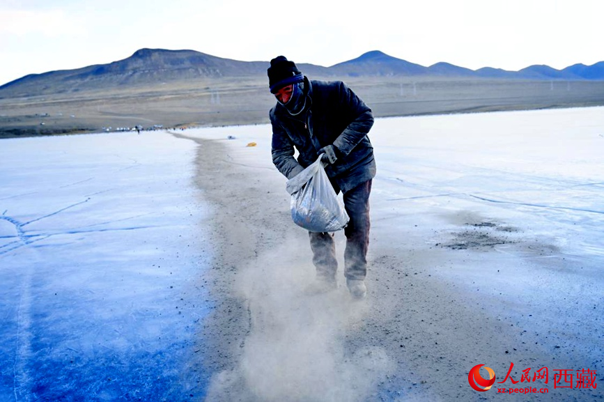 牧民在冰面上撒灰鋪成通道。人民網(wǎng) 李海霞攝