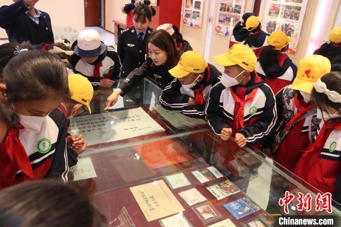 圖為亞?wèn)|邊檢站民警為駐地小學(xué)生講解該站榮譽(yù)發(fā)展史?！『?攝