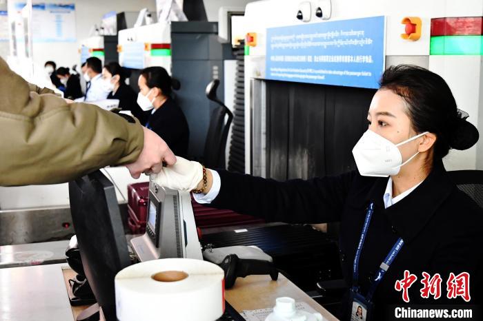 圖為機場工作人員為旅客辦理行李托運?！≈芎?攝