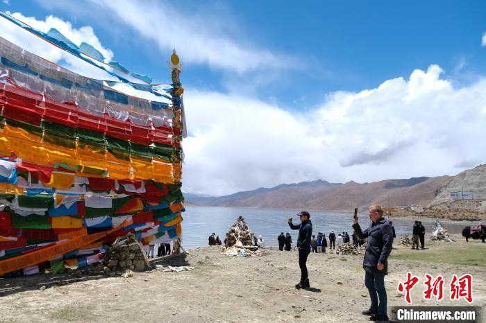 進藏參訪嘉賓在羊湖畔拍攝經(jīng)幡?！〗w波 攝