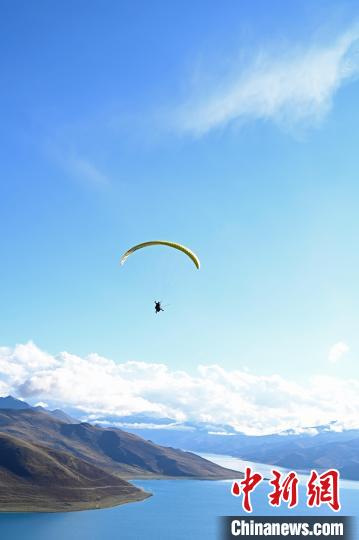 圖為在羊卓雍錯(cuò)，游客體驗(yàn)高空滑翔?！≮w朗 攝