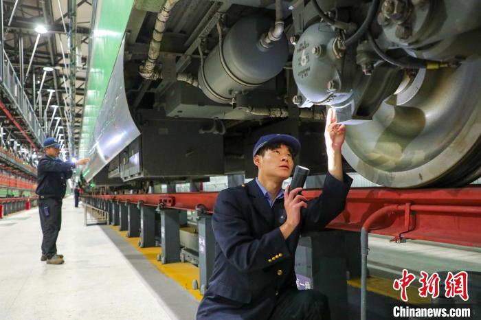 圖為工作人員檢查高原復(fù)興號(hào)?！≈軔傁?攝