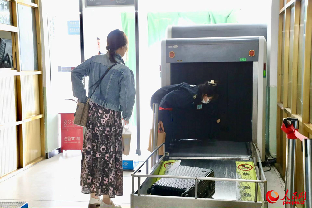 車站工作人員幫旅客提取行李。人民網(wǎng)記者 次仁羅布攝