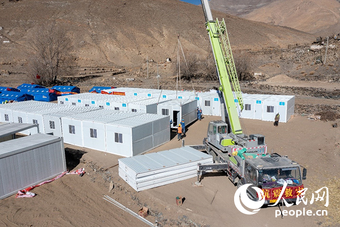 1月9日，在日喀則市定日縣長所鄉(xiāng)古榮村安置點，救援人員和施工人員合力抓緊搭建移動板房，確保受災群眾溫暖過冬。人民網(wǎng)記者 翁奇羽攝