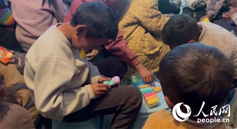 措果鄉(xiāng)塘仁村的孩子們正在用橡皮泥制作自己的情緒“小怪獸”。人民網(wǎng)記者 郝潔攝