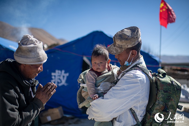 1月9日，在定日縣長(zhǎng)所鄉(xiāng)古榮村安置點(diǎn)，受災(zāi)群眾感謝西藏軍區(qū)陸軍某部隊(duì)衛(wèi)生員的醫(yī)療救治。人民網(wǎng)記者 翁奇羽攝
