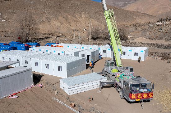 2025年1月9日，在定日縣長所鄉(xiāng)古榮村安置點(diǎn)，救援人員和施工人員合力抓緊搭建移動板房，確保受災(zāi)群眾溫暖過冬。人民網(wǎng)記者 翁奇羽攝