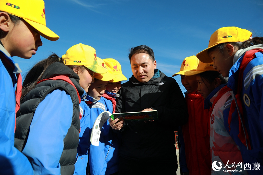 西藏自治區(qū)藏醫(yī)院專家為拉東村小學(xué)生講解天文歷算原理，孩子們圍站聆聽，感受傳統(tǒng)智慧與現(xiàn)代科普的融合。人民網(wǎng)記者 吳雨仁攝