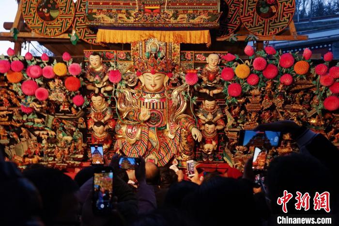 圖為游客觀賞塔爾寺酥油花展，并用手機記錄?！●R銘言 攝