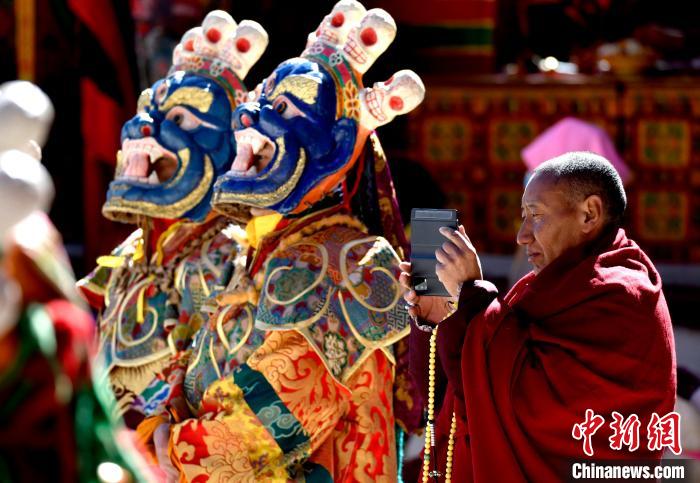 2月19日，正在拍攝跳神活動(dòng)的僧人。　李林 攝
