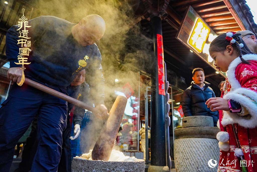 2025年1月29日，浙江省寧波市江北區(qū)慈城古縣城，市民和游客觀看搗年糕。人民網(wǎng) 章勇濤攝