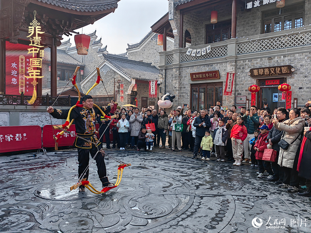2025年1月29日，湖北襄陽(yáng)市管家巷，老北京天橋大刀張舉大刀拉硬弓第五代傳承人現(xiàn)場(chǎng)表演，一次拉開(kāi)6張弓，引來(lái)游客喝彩。人民網(wǎng)記者 郭婷婷攝