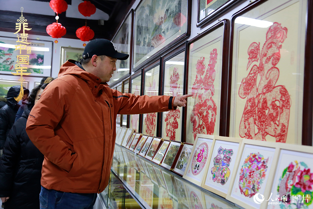 2025年1月23日，游客在天津楊柳青古鎮(zhèn)欣賞傳統(tǒng)剪紙作品，感受指尖上的古老藝術(shù)。人民網(wǎng)記者 崔新耀攝