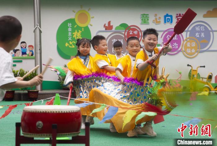 圖為龍舟賽游戲上，小伙伴們打鼓加油?！《^生 攝