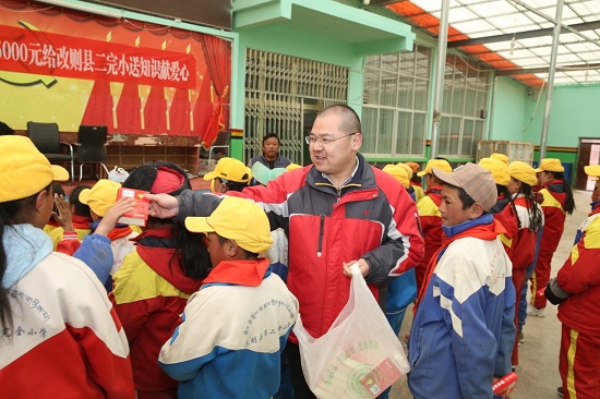 段玉平為孩子們分發(fā)愛心人士捐贈(zèng)的新華字典 圖片來源：央廣網(wǎng).jpg