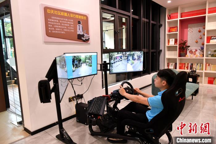 圖為福州中天社區(qū)工作人員正在利用5G技術(shù)，遠(yuǎn)程操控機(jī)器人巡視社區(qū)。　呂明 攝